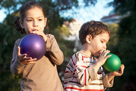 蓝色欢庆摄影照片_孩子们在公园里吹气球