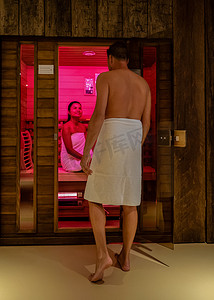 夫妇在桑拿浴室，男人和女人穿着浴袍参观热红外线桑拿浴室