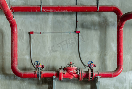 混凝土墙上带门压阀的红水或煤气管道。