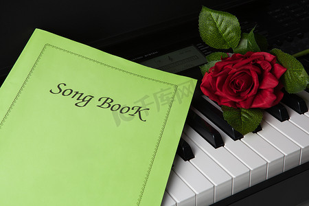 钢琴键、歌本和玫瑰花