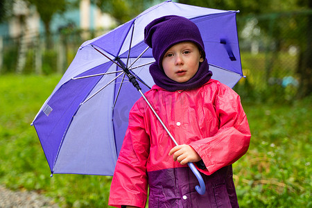 打着伞的孩子在雨中行走。