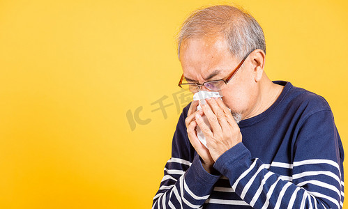 亚洲老人感冒流感和因疾病病毒问题打喷嚏使用纸巾