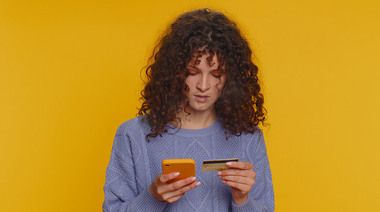 年轻女性在转账购买网上购物时使用信用卡和智能手机