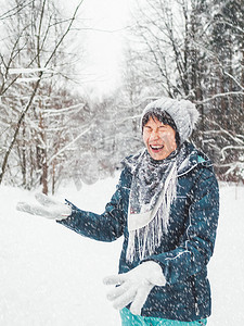 微笑的女人正在玩雪。