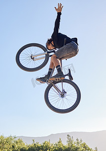 自行车跳跃、男子和户外运动与骑自行车的人和健身、肾上腺素和危险的特技与蓝天和阳光。