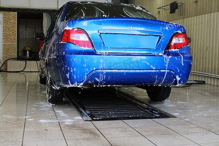 新店开业洗车摄影照片_在洗车的蓝色汽车特写镜头。