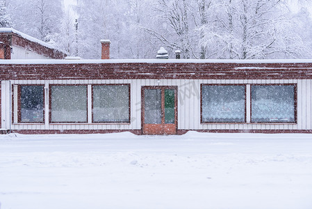 大雪蓝色摄影照片_森林里的房子已经覆盖着大雪和糟糕的天空