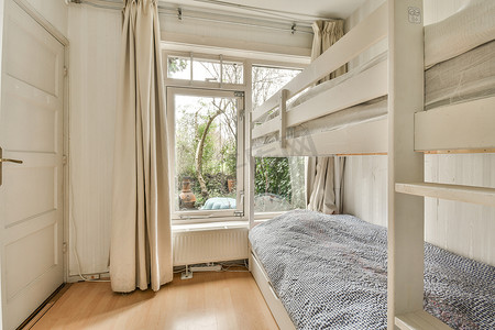 一间带双层床的卧室和一扇带窗帘的窗户