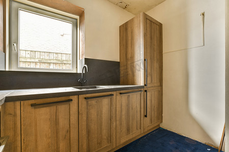 带木柜、水槽和窗户的厨房