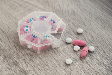 组织者每周拍摄药丸盒的特写镜头，里面装有每天用白色粉红色药物和胶囊服用的药片剂量。