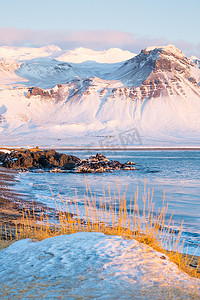 冰岛壮丽山景的日出、火山岩和黄草的海岸、冬季的纯净自然