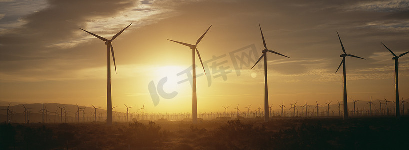 向阳而行摄影照片_风电场涡轮机在黎明