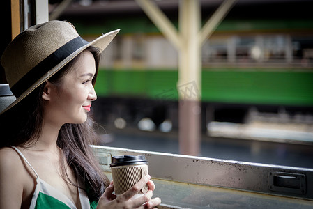 亚洲女旅客在火车上喝咖啡，开心