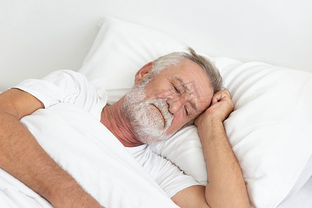 醒着的摄影照片_忧心忡忡的退休老人躺在床上醒着
