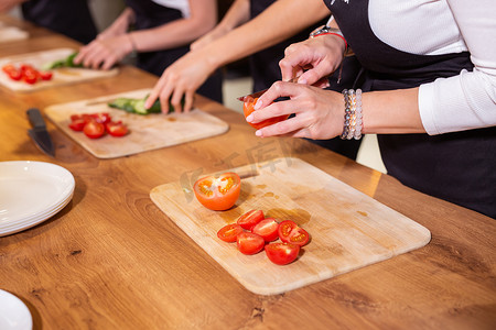 烹饪课程 — 关闭女烹饪班学生在餐厅厨房准备和切割菜肴的配料