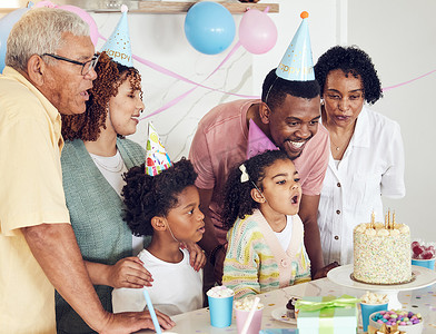 生日、蛋糕和一个女孩在家里与她的黑人家庭庆祝时吹灭蜡烛。