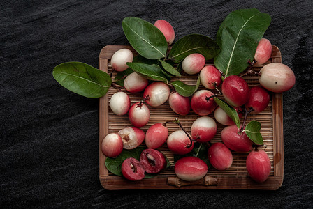 酸味摄影照片_Bengal-Currants、Carandas-plum 或 Karonda 水果 (Carissa carandas L.) 柳条上的酸味水果。