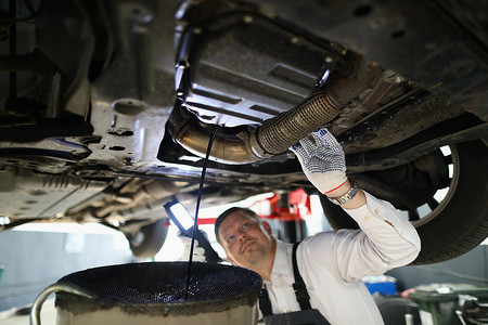 汽车修理工在服务站车库检查发动机