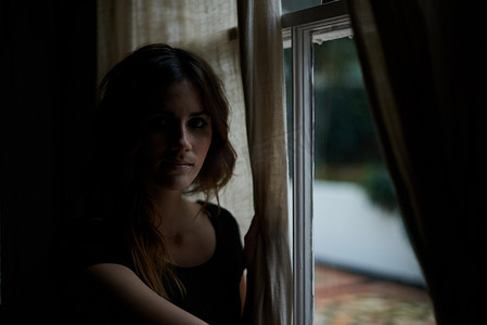 看一看……一位年轻女子在她家窗户上的裁剪肖像。