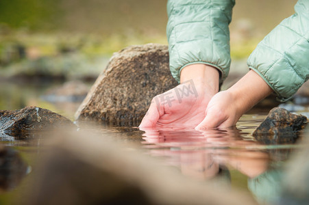 健康水源摄影照片_一个女孩的手和山湖水的特写，大自然，一个干净的水源，可以解渴