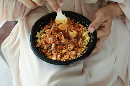 外卖订餐随叫随到摄影照片_妇女们用外卖塑料袋吃咖喱鸡和米饭