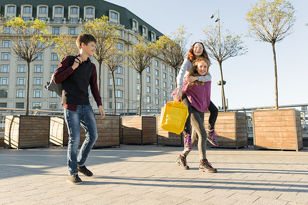 放学路上摄影照片_朋友青少年学生背着书包，在放学的路上玩得开心