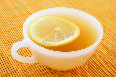 藤条灯摄影照片_一杯柠檬茶在温暖的金色光芒中