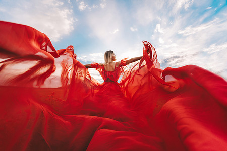 飘动摄影照片_女人红色飞行连衣裙。