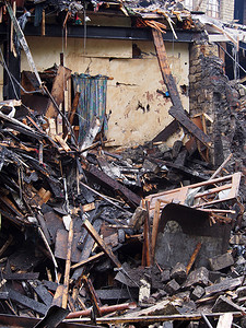 被火烧毁的倒塌房屋中黑色燃烧的木材碎片和墙壁