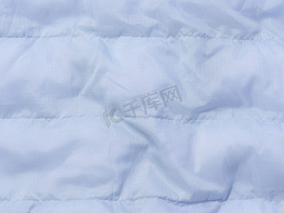 带有羽绒填充和缝合的蓝色织物碎片，用于夹克和外套的织物