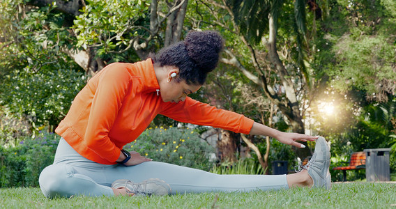 夏天保健摄影照片_黑人妇女在跑步前在公园里伸展腿部以健身、健康和保健。