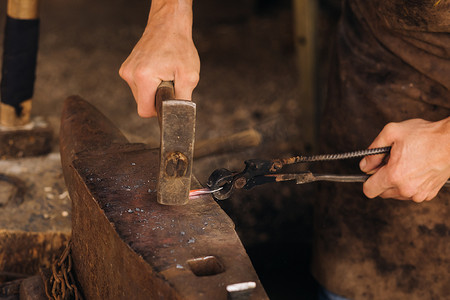 铁匠用锤子在铁砧上手工锻造炽热金属
