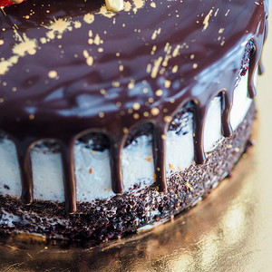 黑金色摄影照片_黑巧克力磨砂滴蛋糕，上面用意大利语写下最美好的祝福