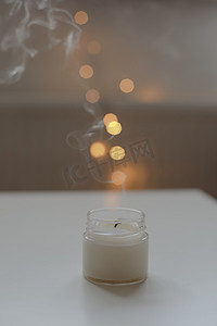 舒适的家居室内装饰，在模糊的灯光下在桌上燃烧蜡烛。