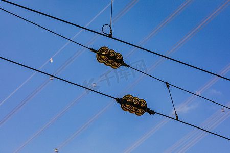 带有铁路线绝缘体的黑色电缆与蓝天相映成趣
