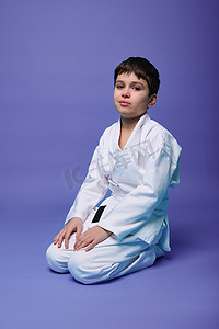 儿童跆拳道摄影照片_欧洲十几岁的男孩-在东方武术实践中穿着白色和服的合气道战士。