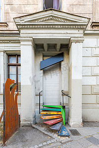 一栋带黑色招牌和彩色金属楼梯的旧建筑的入口前