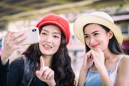 亚洲女性旅行者正在玩手机并为之说话
