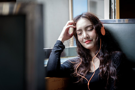 亚洲女性旅行者用电话和橙色 h 听音乐