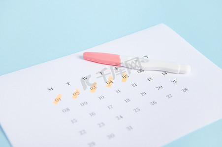 妊娠试验和日历，最后一次月经的日期标记在蓝色背景上。