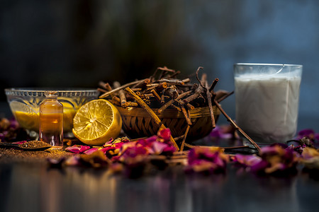 粉利摄影照片_黑色木质表面上的 manjistha 或 Indin 茜草根面罩，由 manjistha 根粉、柠檬、牛奶和一些必需的玫瑰油组成。