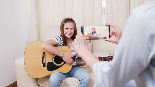 妈妈拍了一段她小女儿弹吉他的视频