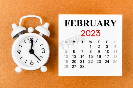 2023 年 2 月组织者计划 2023 年的月历，黄色背景闹钟。