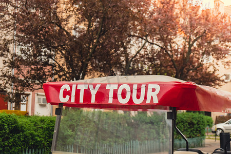 老城区的红城旅游车，带有观光城市旅游的文字标志。