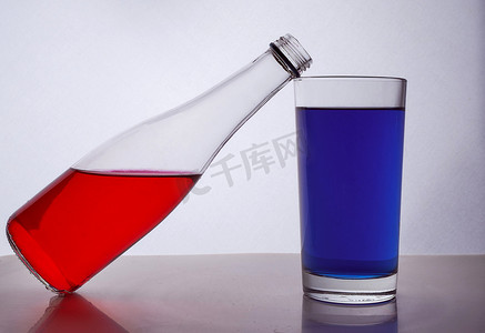 瓶和眼镜与白色背景上的五颜六色的液体组成。