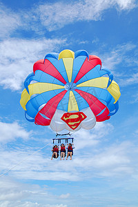航行帆船摄影照片_在长滩岛做降落伞航行娱乐活动的妇女我