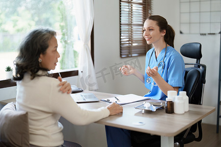 一位女医生的肖像与肩痛患者讨论。
