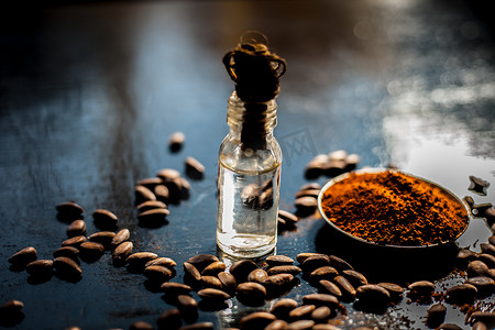 黑色木质表面抗衰老的咖啡面膜，由一些咖啡豆和生有机椰子油组成，装在一个小玻璃瓶中。