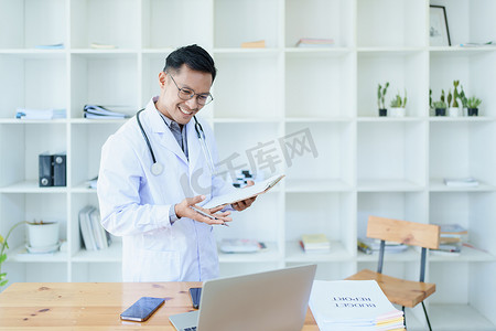 医生在工作中使用文档和计算机治疗疾病前查看患者信息的肖像