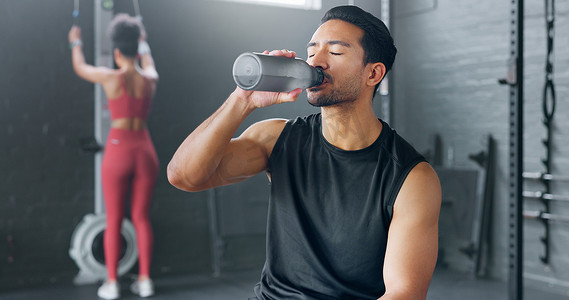 男人，在健身房锻炼、训练和运动休息中疲倦和饮用水，以恢复能量和肌肉休息。